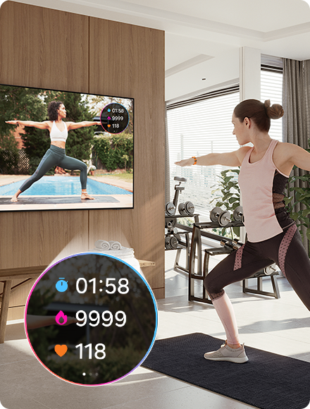 Žena radi jogu dok gleda instruktora na TV-u. TV takođe prikazuje statistiku vežbe 01:58, 9999, 118 sa povezanog Galaxy Watch sata.